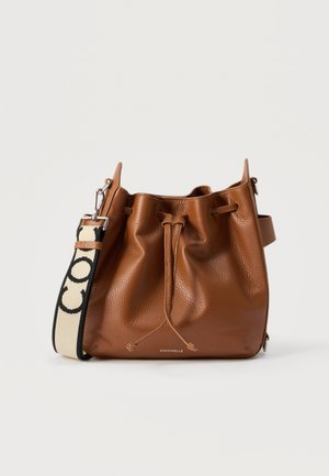 Καφέ δερμάτινη τσάντα τύπου πουγκί με κορδόνι κλεισίματος και μπεζ-μαύρο ιμάντα ώμου με λογότυπο, σε λευκό φόντο.