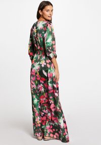 Abito lungo in tessuto morbido con motivo floreale nei colori verde, rosa e giallo. Presenta una vita arricciata e maniche a palloncino.