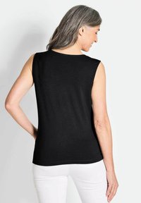 Schwarzes ärmelloses Oberteil, aus leichtem Stoff, figurbetontem Design, glatte Textur, abgerundeter Saum, von hinten gezeigt mit sichtbarem grauem Haar.