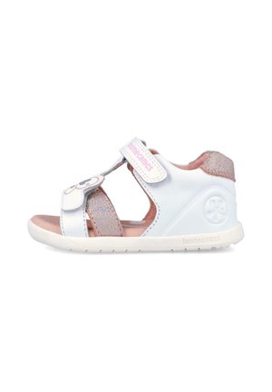 Sandalia para niño pequeño en blanco y rosa con correas ajustables, suela acolchada suave y diseño floral en la correa delantera.