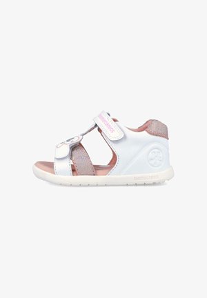 Sandalia para niño pequeño en blanco y rosa con correas ajustables, suela acolchada suave y diseño floral en la correa delantera.