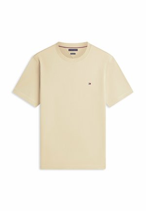 Beige T-shirt met korte mouwen en een ronde hals, met een klein Tommy Hilfiger-logo op de linkerborst, platgelegd op een witte achtergrond.
