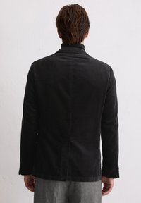 Czarna marynarka sztruksowa o slim fit, z pojedynczym rozcięciem z tyłu oraz dopasowanymi klapami, z teksturowanej tkaniny i z guzikami na mankietach.