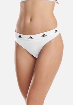 Weißer Baumwoll-Thong mit breitem elastischem Bund, der mit schwarzen Adidas-Logos versehen ist. Glatte Textur, minimale Abdeckung und enganliegendes Design.