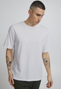 Witte katoenen t-shirt met korte mouwen, ronde hals, ontspannen pasvorm en een gladde textuur. Geen zichtbare patronen of logo's.
