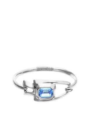 Bracelet en argent conçu comme une épingle de sûreté avec une grande pierre précieuse rectangulaire bleue sertie au centre.