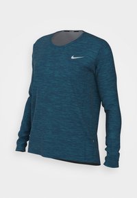 Long-sleeve athletic shirt in teal, featuring a textured fabric, round neckline, and a white Nike logo on the upper left chest.