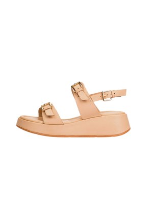 Sandalia de plataforma beige con dos correas ajustables con hebilla sobre el pie y una alrededor del tobillo, mostrada de perfil sobre fondo blanco.