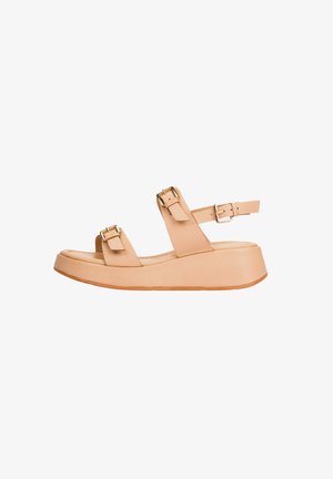 Sandalia de plataforma beige con dos correas ajustables con hebilla sobre el pie y una alrededor del tobillo, mostrada de perfil sobre fondo blanco.