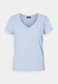 Ljusblå bomullströja med V-udden, korta ärmar och en liten broderad logotyp på vänster bröst. Mjuk textur, avslappnad passform.