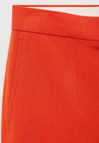 Oranžni tkaninski hlače z gladko teksturo, ki imajo stranske žepke in ravno pasnico. Material ima rahlo sijoč videz in strukturirano zasnovo.