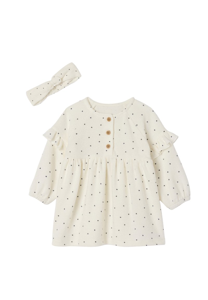 Cremfarbendes Kleid mit schwarzen Punkten, Rüschensäumen und Holzknöpfen. Enthält ein passendes Kopfband mit einem verknoteten Design.