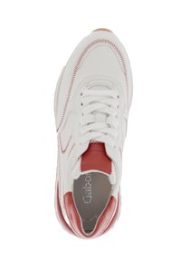 Witte sneaker met rode leren accenten, gestructureerde stiksels en platte witte veters. Gevoerde zool en een glad oppervlak. Rond design van de neus.