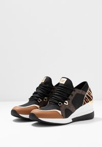 Czarne i brązowe sneakersy z teksturowanym materiałem, złotymi akcentami, wyściełanym kołnierzem oraz wzorem w mieszane cętki i paski tygrysa.