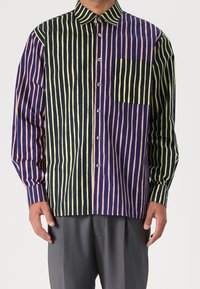 Overhemd met knopen en gedurfde verticale strepen in marineblauw, roze en groen. Kenmerkt zich door een kraag, lange mouwen en een borstzak. Zachte stof.