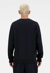 Zwarte sweatshirt met lange mouwen, ronde hals en geribbelde manchetten en zoom. Zacht materiaal en minimalistisch ontwerp, gezien vanuit de achterkant.