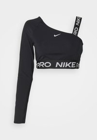 Svart Nike crop topp med lange ermer, asymmetrisk design, med en bred elastisk midjebånd med "PRO NIKE" i grå bokstaver og en enkelt skulderstropp.