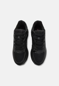 Black athletic shoes with a combination of mesh and synthetic materials. Features flat laces, padded collar, and textured rubber sole.