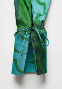 Material textil cu un model verde și teal, având un sistem de închidere cu șnur, ce prezintă forme geometrice și o fanta la tiv. Textură netedă.