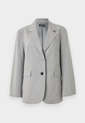 Lys grå blazer med nålestriber, med hakkede slag, to fremre lommer med klaff, og to knapper i forskjellige farger på frontlukningen.