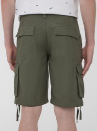 Pantaloni cargo verde oliva con molte tasche laterali, orli con cordoncino e una texture di tessuto resistente, visti da dietro.