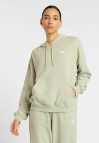 Haut à capuche vert clair en tissu doux, doté d'une poche avant, de cordons de serrage et d'un petit logo blanc sur la poitrine.