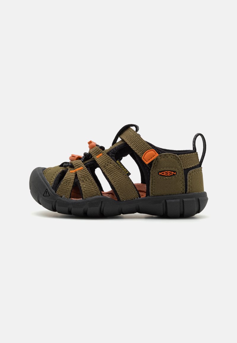 Barnesandaler med en mørk olivenfarge på overdelen i stoff, svart gummisåler og oransje detaljer; har flere stropper for ventilasjon.