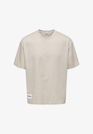 T-shirt corto di colore beige chiaro realizzato in tessuto morbido. Presenta un collo tondo e un'etichetta cucita all'orlo con la scritta "EXTEND."