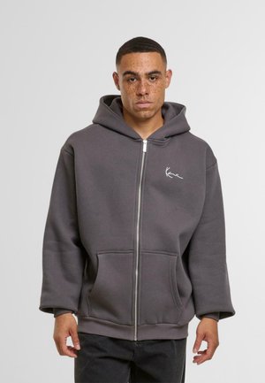 Gray zip-up hoodie made of soft fabric, features a front zipper, large pockets, and a small white logo on the left chest area.