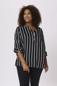Black and white striped blouse with a V-neck, button detail, and rolled sleeves. Soft texture, relaxed fit, paired with black pants.
