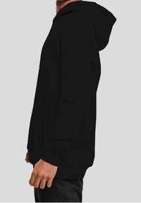 Felpa con cappuccio nera realizzata in tessuto misto cotone. Presenta una tasca a marsupio frontale e polsini a costine. Design semplice senza motivi visibili.