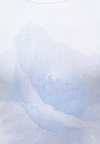 Κοντινή λήψη λευκού υφάσματος με ανοιχτό μπλε πουά μοτίβο που μοιάζει με διπλωμένο, αφηρημένο λουλούδι ή σχήμα φύλλου.