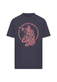 Navy t-shirt featuring a pink graphic design with the text "ROCKET MAN" and "Elton John," depicting a figure pointing with a flamboyant outfit.