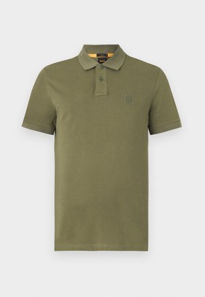 Polo shirt verde oliva realizzato in cotone, con una chiusura a tre bottoni, maniche corte e una piccola etichetta con logo sul petto.