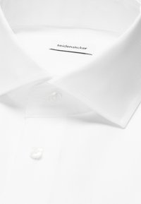 Chemise blanche classique avec col pointu, boutons visibles et étiquette à l'intérieur du col indiquant "seidensticker."