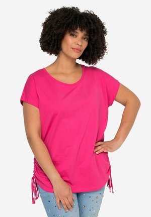 Lys pink kortærmet t-shirt med rund udskæring og sidesnor. Blødt materiale med en afslappet pasform. Kombineret med pyntede lyseblå jeans.
