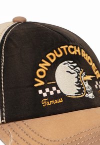 Gorra negra y caqui con el texto bordado "VON DUTCH RIDER", un diseño de calavera y acentos a cuadros en el panel frontal.