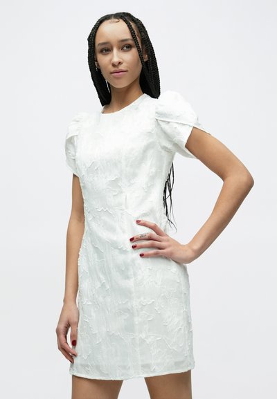 Bela obleka z reliefnim cvetličnim vzorcem, kratkimi napihnjenimi rokavi in ravno silhueto. Gladek material z nežnim sijajem.