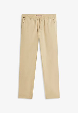 Pantalon décontracté beige avec ceinture élastique et cordon de serrage, poches latérales, et coupe droite.