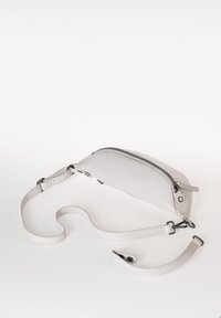 Borsa in pelle grigia con forma curva, dotata di chiusura con zip superiore e tracolla regolabile, texture liscia e dettagli hardware minimi.