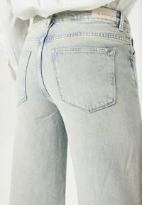 Lichtblauwe denim jeans met een relaxte pasvorm, voorzien van een hoge taille, vijf zakken en subtiele vervaging, gemaakt van een gestructureerde stof.