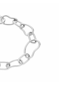 Bracelet en argent avec des maillons de chaîne alternant entre formes arrondies et irrégulières sur fond blanc.