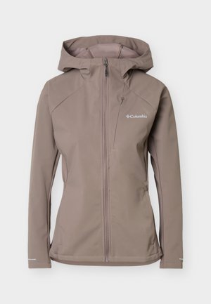 Taupe-colored Columbia softshell jacket with hood, front zipper, chest pocket, and long sleeves showing logo on the right chest.