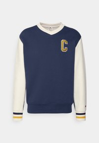 Námořnická mikina s bílými rukávy a pruhovanými manžetami. Má výstřih do „V“ a vyšívané zlaté písmeno „C“. Měkký materiál s pohodlným střihem.