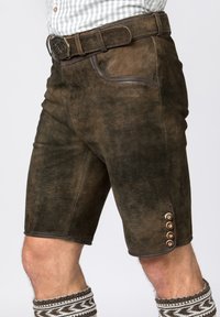 Brune lædershorts har frontlommer og dekorative knapper på siden, parret med mønstrede knæstrømper.