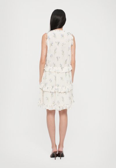 Blomstrete sommerkjole i lett kremfarget stoff, med volanger, justerbare skulderstropper og en avslappet passform. Mønsteret har små blå blomster.