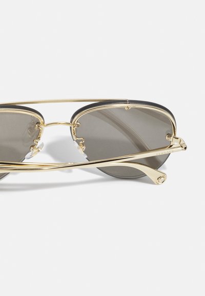 Gold metal frame sunglasses with gray lenses, featuring a sleek design, subtle curvature, and detailing on the arms, including logo accents.