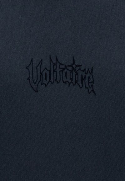 Μαύρο ύφασμα με ανάγλυφο μαύρο γοτθικό κεντητό κείμενο "Voltrafome" στο κέντρο.