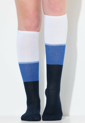Calze lunghe fino al ginocchio con texture a costine e blocchi di colore orizzontali: bianco, azzurro, blu scuro e blu navy sulla parte del piede.