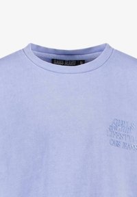 Lichtpaarse katoenen t-shirt met een ronde hals, met reliëftekst aan de linkerkant die "GIRLS CLUB LIFESTYLE CARS JEANS" leest.
